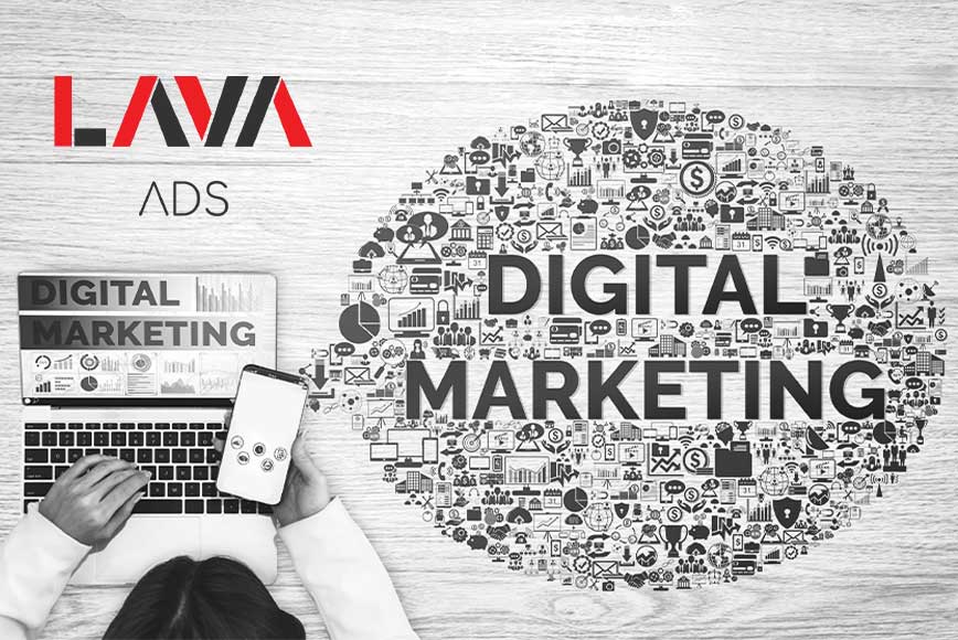 Mitovi i činjenice o digitalnom marketingu: Šta zaista funkcioniše? Digitalni marketing ispisan u oblačiću ikonica na radnom stolu i osoba koja sedi za računarom dok koristi mobilni telefon iz ptičije perspektive.