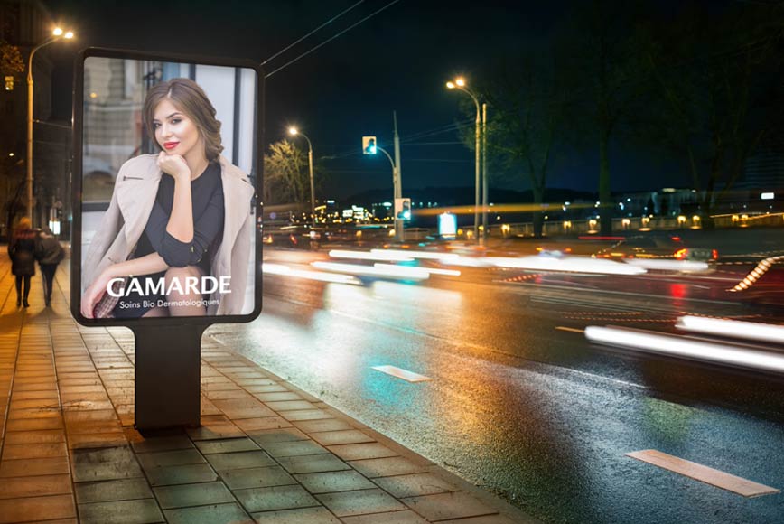 Osvetljeni LED bilbord uz cestu u gradu s reklamom za Gamarde Srbija kozmetiku.